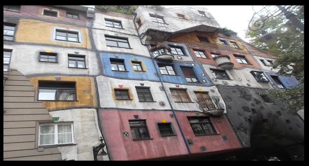 Bildbeschreibung: Auf dem Bild 1 ist ein Wohngebäude mit unterschiedlichen Fenstergrößen und -formen sowie einer verschieden farbig gestalteten Hausfassade zu sehen. Ende der Bildbeschreibung.