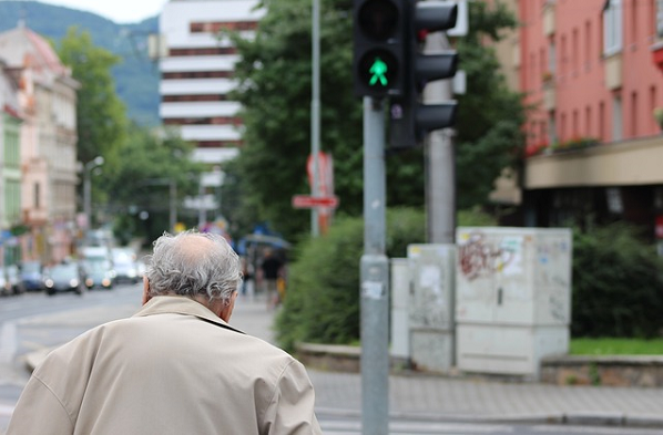 Bildbeschreibung: Das Bild zeigt einen älteren Mann, wie er gerade bei grün die Straße überquert. Ende der Beschreibung.