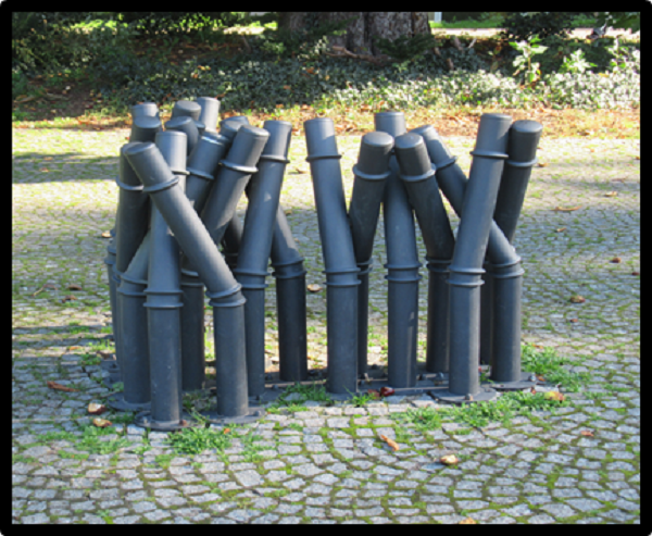 Das Bild 1 zeigt eine Skulpturengruppe aus mehreren Pollern, die teilweise gebogen sind.