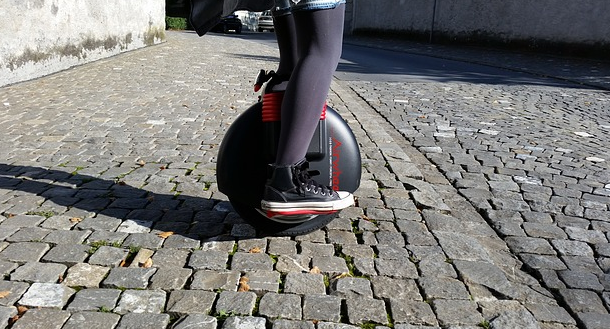 Bild 3 zeigt eine auf einem Luftrad stehende Person auf einem Gehweg. 