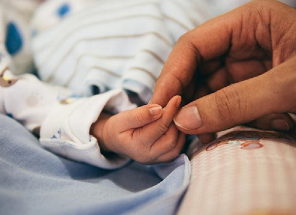 Bild 2 zeigt eine Frauenhand, die eine Babyhand berührt. 