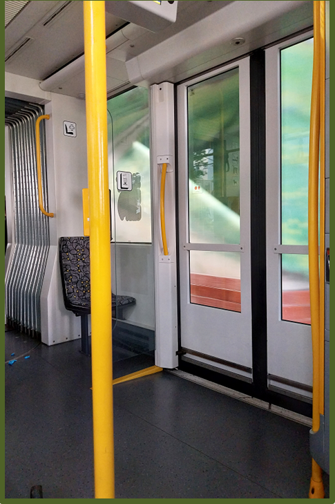 Bild 4 zeigt eine gelbe Haltestange in einer Straßenbahn.