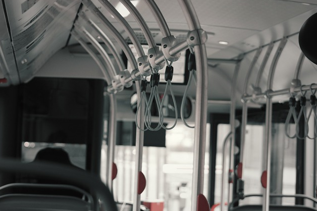 Bild 2 zeigt Edelstahlhaltestangen und graue Festhalteschlaufen in einem leeren Bus.