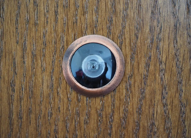 Bild 1 zeigt einen runden Spion an einer braunen Wohnungstür.