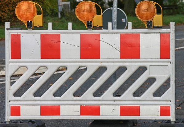 Bild 3: rot-weiß gestreiftes Absperrschrankengitter mit 3 darauf befestigten Warnleuchten