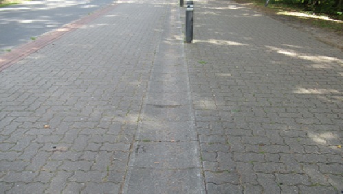 Radweg (links) wird durch eine Muldenrinne (Bildmitte) vom Gehweg (rechts) getrennt
