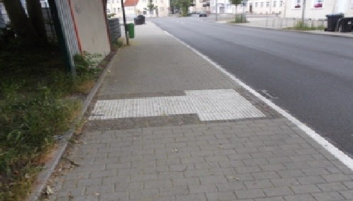 Bild 5: Auffindestreifen aus Bodenindikatoren zur Kennzeichnung einer seitlich am Gehwegrand liegenden Bushaltestelle quer über den gesamten Gehweg wird bis zur inneren Leitlinie, bestehend aus Rasenkantensteinen, geführt